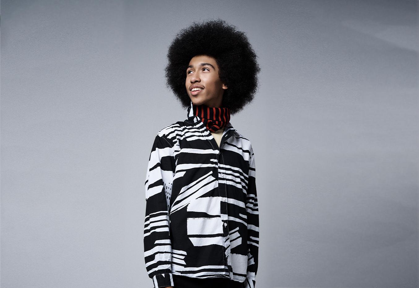 Tabay Atkins, boy waring a black and white button down shirt with head turned, looking to the side